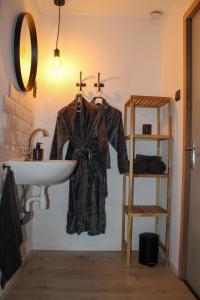 NiawierGrytmanshoeve, Vakantiehuis met glamping的挂在水槽旁墙上的长袍