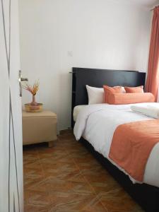 ThikaBloom private home的一间卧室配有两张带橙色和白色枕头的床