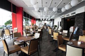 乔治市Hotel Sentral Seaview @ ​Beachfront的餐厅设有木桌和椅子,拥有红色的墙壁