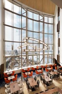 悉尼Shangri-La Sydney的餐厅设有桌椅和大窗户。