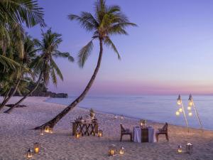 长滩岛Shangri-La Boracay的棕榈树海滩上的桌椅