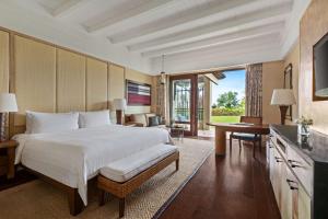 长滩岛Shangri-La Boracay的一间卧室配有一张大床、一张桌子和一张桌子