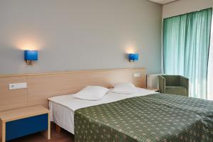 库雷萨雷Asa Spa Hotel的配有一张床和一把椅子的酒店客房