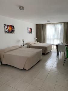 罗萨里奥托雷波托西公寓的酒店客房设有两张床和一张桌子。
