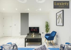 滨海绍森德City Centre - Modern Apartment - by Luxiety Stays Serviced Accommodation Southend on Sea -的客厅配有蓝色椅子和桌子