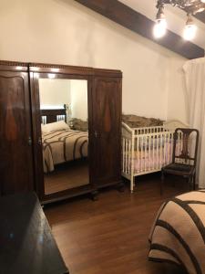 PlasenzuelaCasa - apartamento rural La Tahona del abuelo的一间卧室配有大镜子和婴儿床