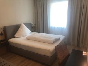 拜尔恩格里斯Altstadthotel Millipp的一张带白色枕头的床和一个窗户