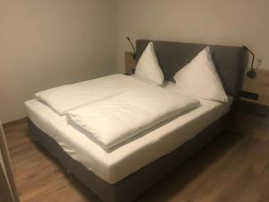 拜尔恩格里斯Altstadthotel Millipp的一张带白色床单和枕头的床