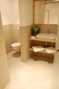 拜尔恩格里斯Altstadthotel Millipp的一间带水槽、卫生间和镜子的浴室