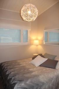 索特Villa Lakia的一间卧室配有一张床、一盏灯和窗户