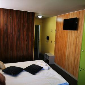 乌斯特龙艾勒梅尔普兰厄特酒店的一间卧室配有一张带两个黑色枕头的床