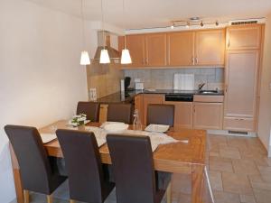 南达Apartment Grand Panorama C5 by Interhome的一间带木桌和椅子的厨房以及一间用餐室