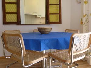 采尔马特Apartment Imperial-5 by Interhome的一张带椅子的蓝色桌子和碗