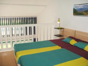 米尼赞海滩Apartment Cap Océan by Interhome的一间卧室配有一张色彩缤纷的床和一个阳台