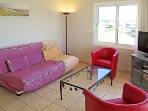 米尼赞海滩Apartment Côte Sud-3 by Interhome的客厅配有紫色沙发和红色椅子