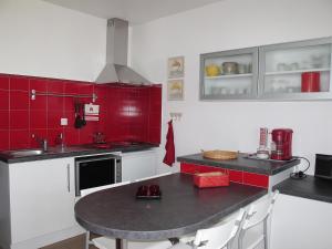 米尼赞海滩Studio Horizon-1 by Interhome的厨房拥有红色和白色的墙壁,配有桌子