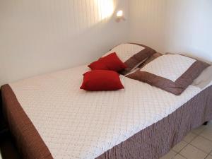 米尼赞海滩Studio Horizon-1 by Interhome的床上有两个红色枕头的床
