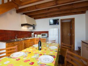 米尼赞海滩Holiday Home Sicard-9 by Interhome的厨房配有一张桌子,上面放着一瓶葡萄酒