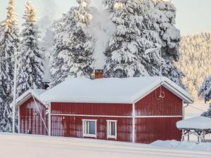 UnariHoliday Home Villa unari by Interhome的雪覆盖在雪覆盖的树前的红谷仓