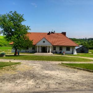 桑多梅日格斯涅克胡沙尔斯基农家乐的白色的房子,有红色的屋顶和一棵树