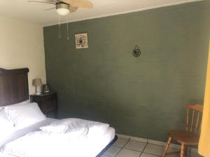 博恩比德迈住宿加早餐旅馆的一间卧室设有绿色的墙壁、一张床和一把椅子