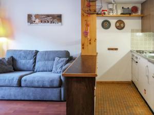 南达Apartment Beau-Séjour 24 by Interhome的一间带蓝色沙发的客厅和一间厨房