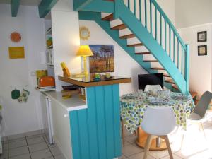 米尼赞海滩Apartment Horizon-2 by Interhome的厨房配有桌子和蓝色的楼梯