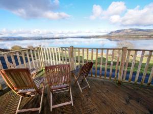BallingryChalet Loch Leven Lodge by Interhome的湖景甲板上的两把椅子