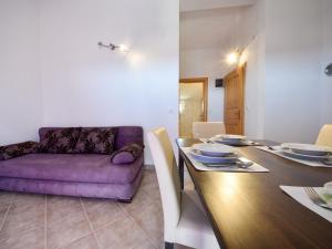耶泽拉Apartment Milin-3 by Interhome的一间用餐室,配有一张紫色的沙发和一张桌子