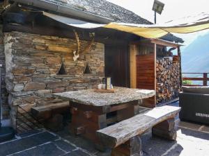 MalvagliaHoliday Home Rustico Catcüc by Interhome的石头建筑,带桌子和长凳