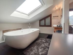 SchmittenHoliday Home Haus Chappali by Interhome的浴室配有白色浴缸,设有天窗