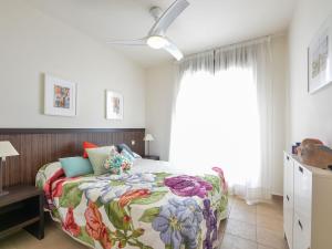 米哈斯科斯塔Apartment Alamar by Interhome的一间卧室配有一张带花卉床罩的床
