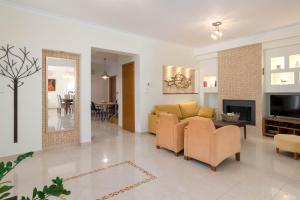 伊利索斯Chrissiida Villa的客厅设有黄色沙发和电视