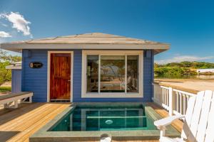 罗阿坦Barefoot Cay Resort的甲板上设有游泳池的房子