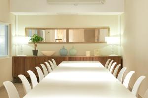 巴塞罗那奥姆尼姆酒店的一间带长桌和白色椅子的用餐室