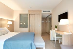 巴塞罗那奥姆尼姆酒店的卧室配有1张床、1张书桌和1张桌子及椅子