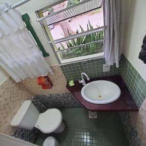 弗洛里亚诺波利斯Pousada Quintal Verde Floripa的一间带水槽和卫生间的浴室以及窗户。