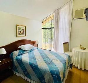 利马Villas Del Sol Bed & Breakfast的一间卧室设有一张床和一个窗口