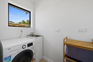 格雷敦Greytown Getaway - Greytown Holiday Home的带窗户的客房内的洗衣机