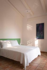 焦亚德尔科莱Agriturismo La Civetta的卧室配有白色的床和墙上的绘画作品