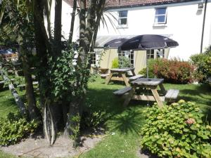 圣萨维尔吉姆塞Longfrie Inn的院子里的野餐桌和雨伞