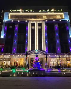 拉斯阿尔卡麦Camphor Hotel的一座建筑,在晚上前方有一个喷泉