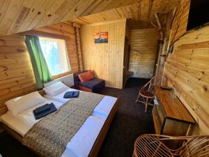 德拉格布拉特Alpin Eco Chalet & Wellness的小屋内一间卧室配有一张床和一张书桌