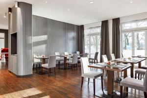 汉堡汉堡市NH系列酒店的用餐室设有桌椅和窗户。