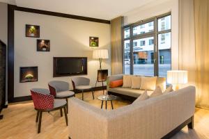 纽伦堡纽伦堡NH系列城市的客厅配有沙发、椅子和电视