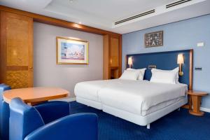 海牙海牙NH亚特兰大酒店的酒店客房带一张床、一张桌子和椅子