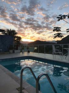 安格拉杜斯雷斯Sua casa的一座享有日落美景的游泳池