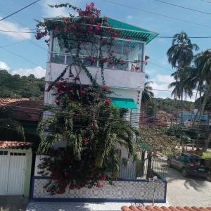 Barra do CamaragibePousada Tiriri Guesthouse的花朵边的建筑