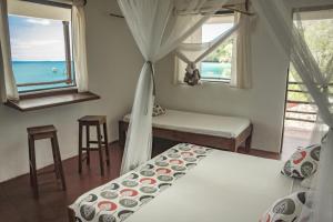 MadirokelyChez Senga的一间带两张床的卧室,享有海景