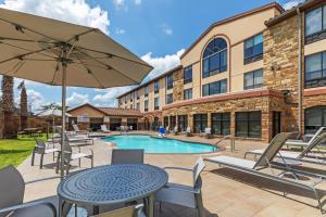 莱克韦Holiday Inn Express & Suites Austin NW – Lakeway, an IHG Hotel的一个带桌椅的庭院和一个游泳池